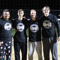 Students wearing championship shirts from a lower bracket sand volleyball tournament